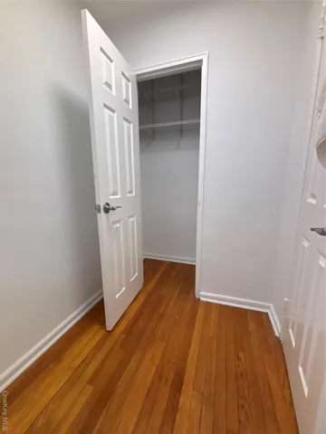 an empty room with wooden floor and entrance