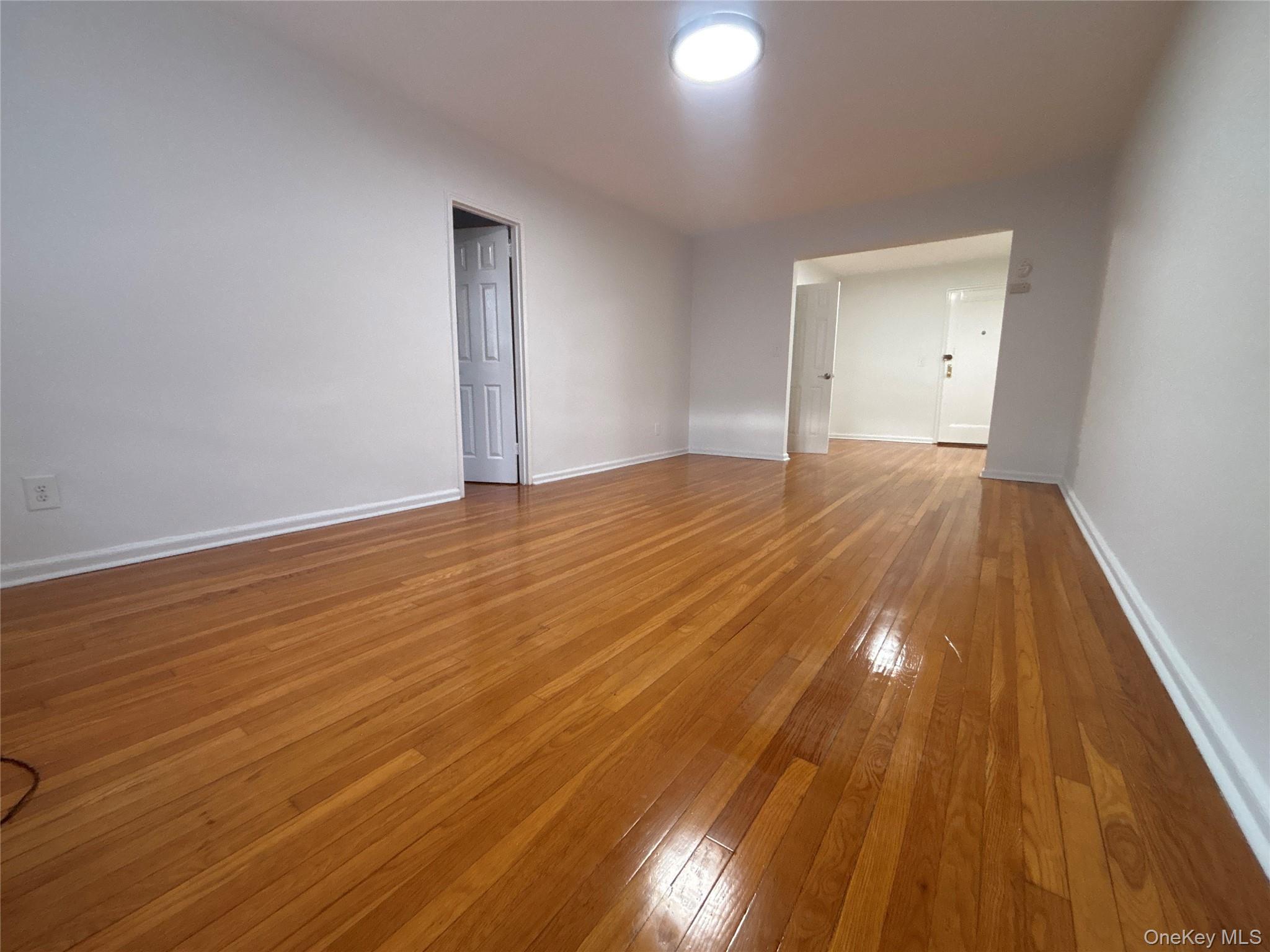 50 South Middle Neck Road, Unit 2L Great Neck, NY 11021 - Photo 9 of 12 a view of an empty room with wooden floor and a window