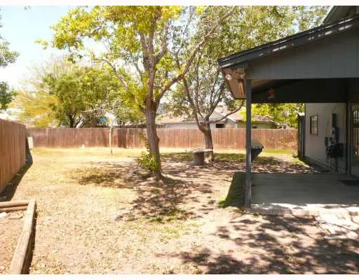 a view of a yard with wooden fence