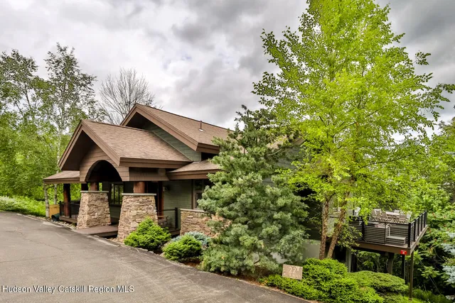 a view of a house with brick walls and a tree