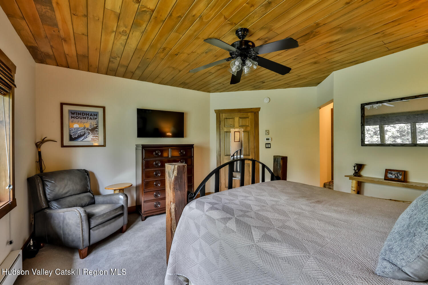 22 Club Road Windham, NY 12496 - Photo 24 of 41 a bedroom with a bed a couch and a flat screen tv