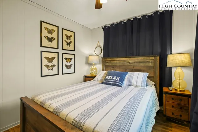 a bedroom with a bed and a lamp on dresser