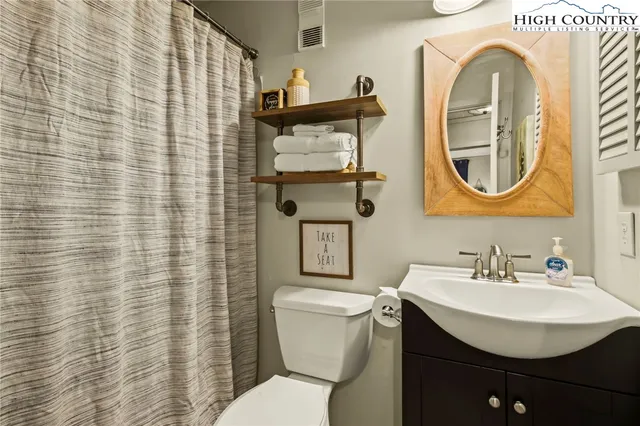 a bathroom with a toilet a sink and mirror
