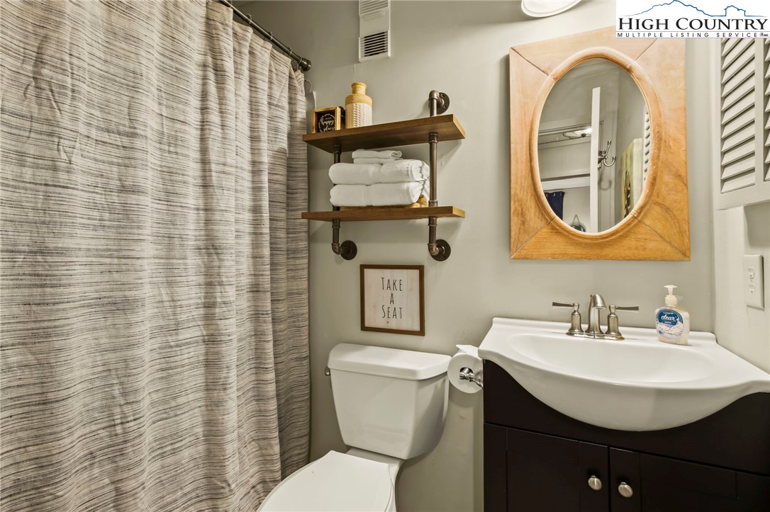 301 Pinnacle Inn Road, Unit 3301 Beech Mountain, NC 28604 - Photo 10 of 18 a bathroom with a toilet a sink and mirror