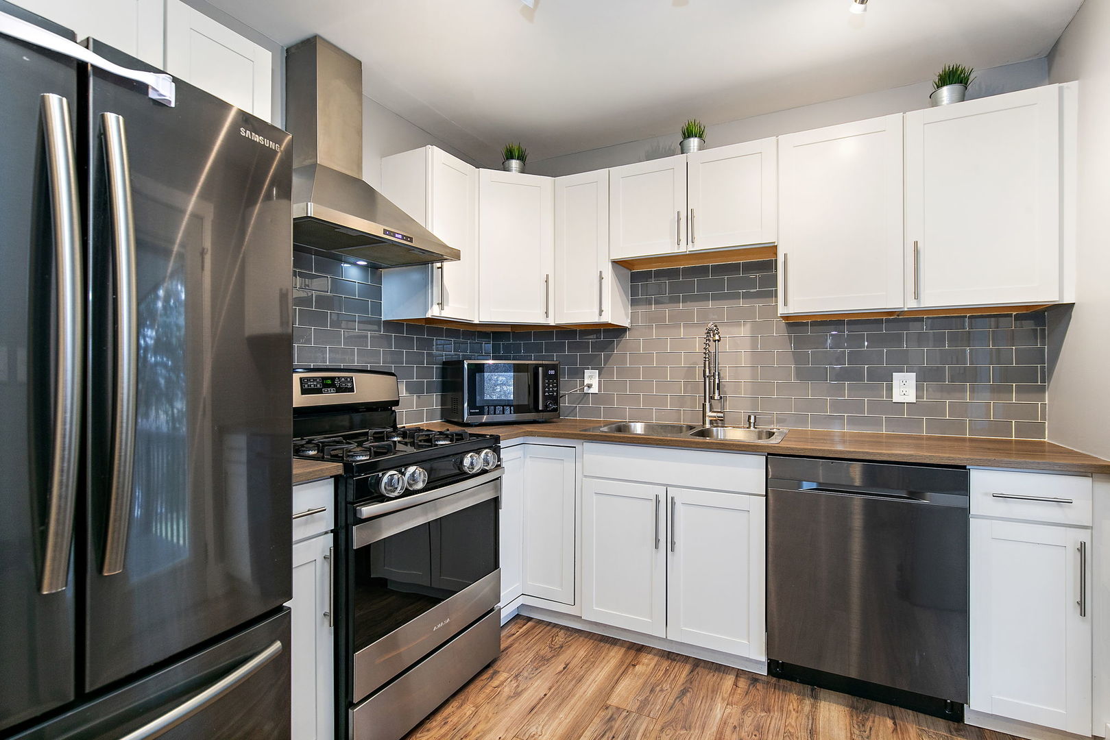 1014 Vine Street Streamwood, IL 60107 - Photo 7 of 23 a kitchen with stainless steel appliances granite countertop a refrigerator a sink dishwasher a stove and white cabinets with wooden floor