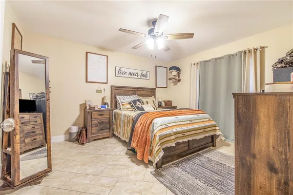a bedroom with a bed and a refrigerator