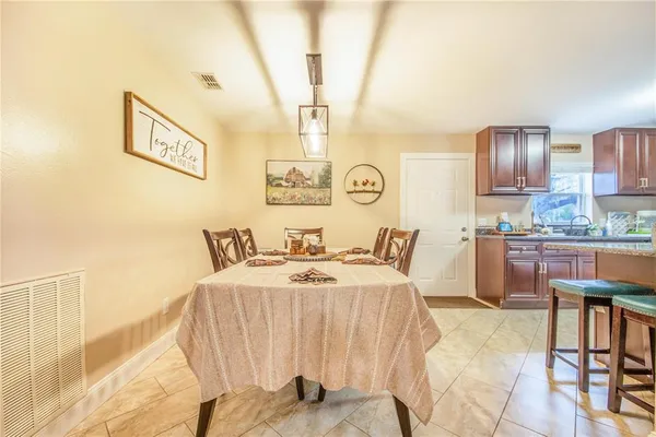 a living room with stainless steel appliances furniture a fireplace and a kitchen view