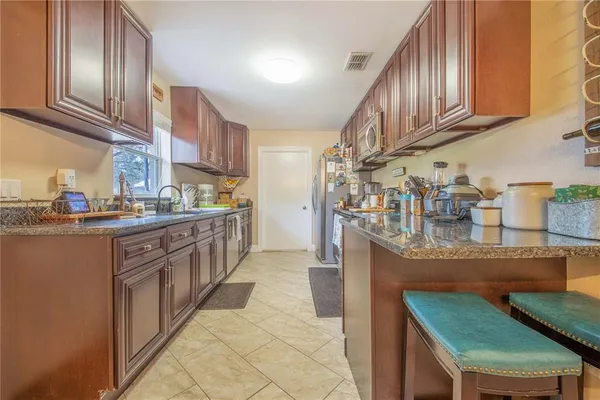 a kitchen with stainless steel appliances granite countertop a sink stove and cabinets