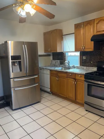 a kitchen with stainless steel appliances granite countertop a sink and a refrigerator