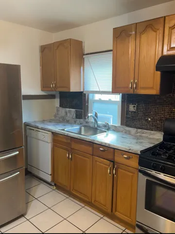 a kitchen with granite countertop a sink stainless steel appliances and cabinets