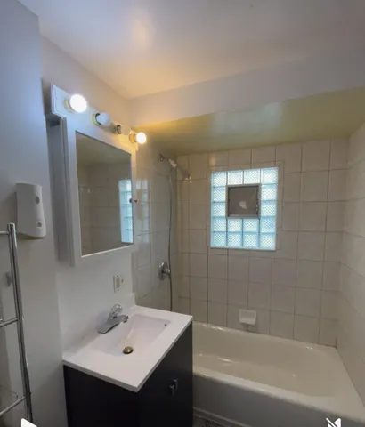 a bathroom with a sink mirror and a bathtub
