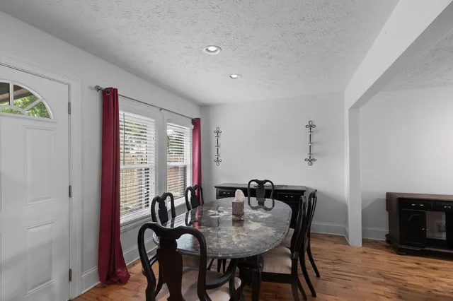a view of a a dining room with furniture window and wooden floor