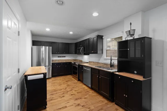 a kitchen with stainless steel appliances granite countertop refrigerator a sink and a stove