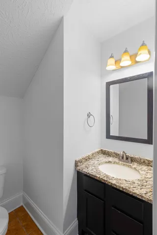 a bathroom with a granite countertop sink and a mirror