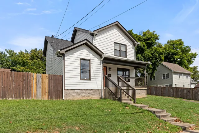 a view of backyard of house with deck and outdoor seating