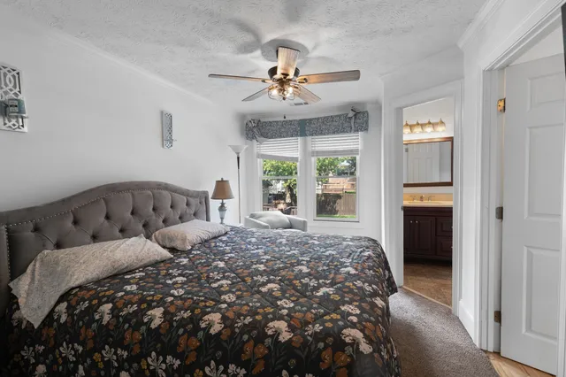 a bedroom with a large bed and ceiling fan