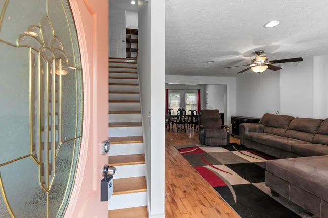 a living room with furniture a flat screen tv and a chandelier