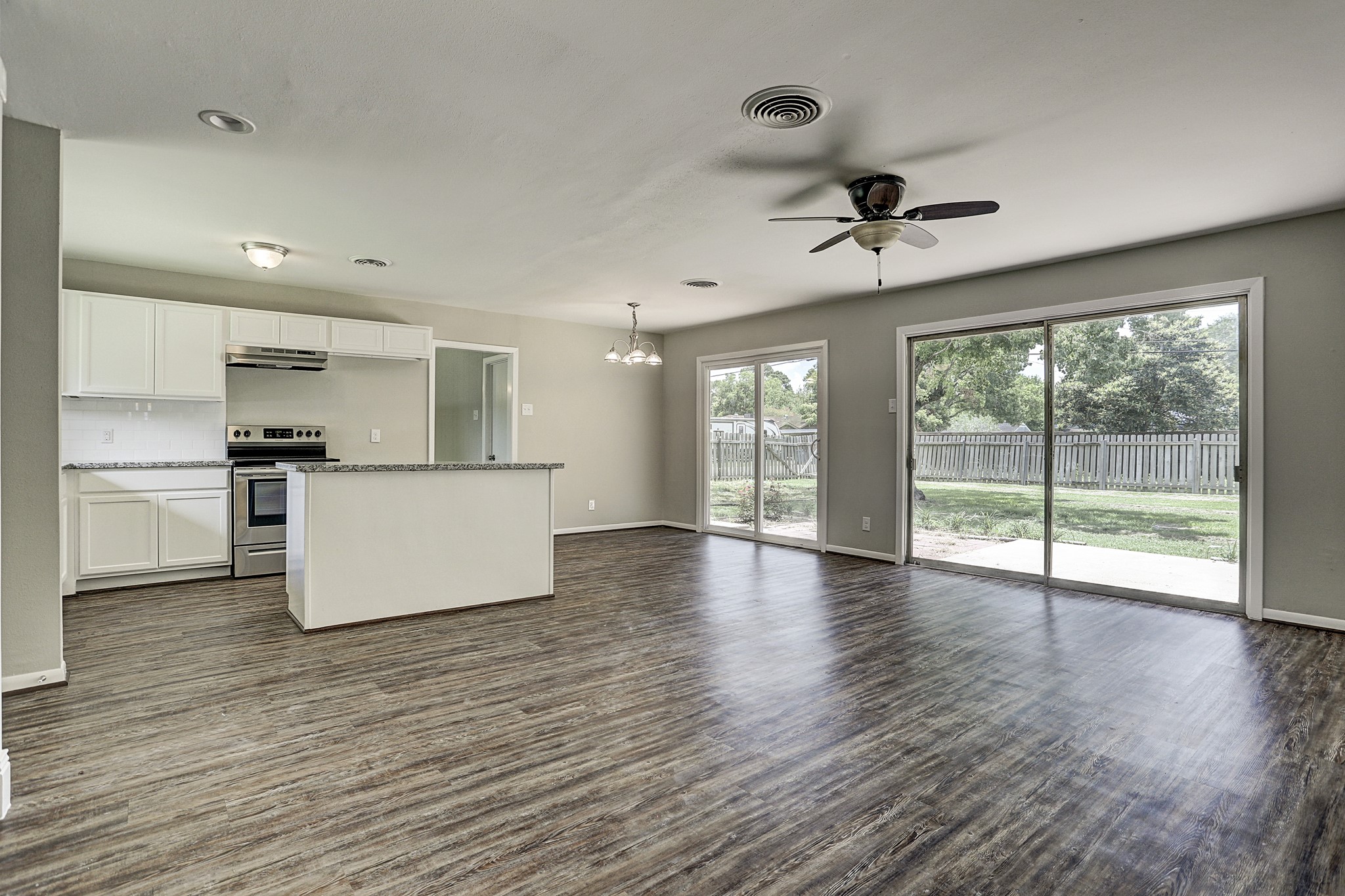 1803 Jones Street Rosenberg, TX 77471 - Photo 5 of 11 a view of an empty room with wooden floor and a kitchen