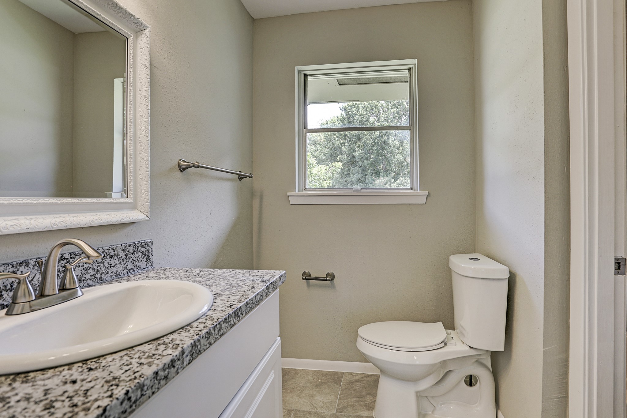 1803 Jones Street Rosenberg, TX 77471 - Photo 9 of 11 a bathroom with a granite countertop toilet a sink and a mirror