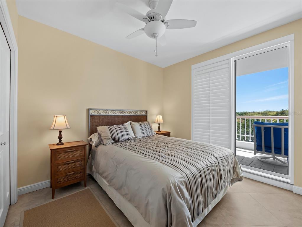 455 Longboat Club Road, Unit 402 Longboat Key, FL 34228 - Photo 19 of 48 a bed room with a bed and a chandelier