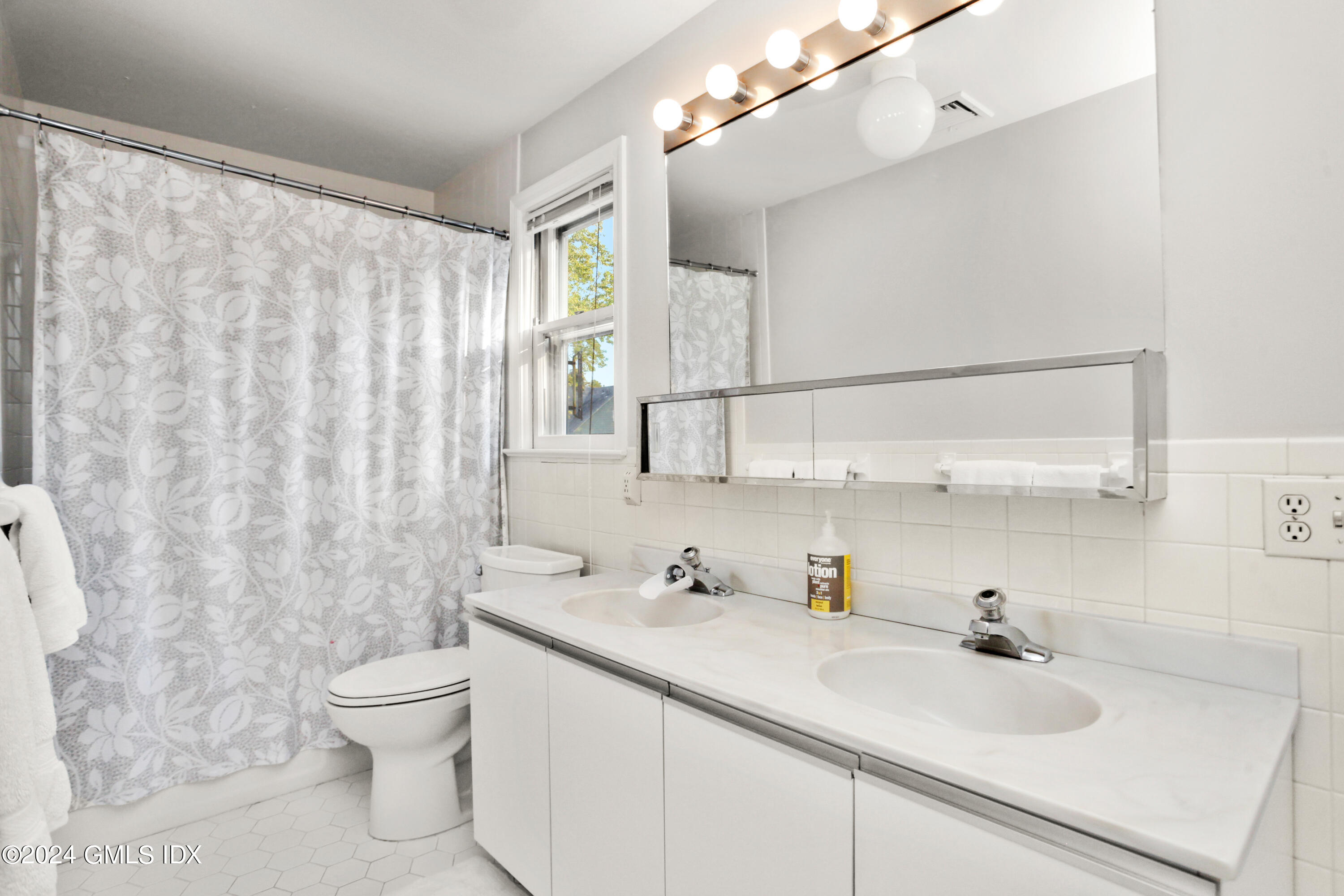 18 Shore Road Old Greenwich, CT 06870 - Photo 17 of 51 a bathroom with a sink a toilet and shower curtain