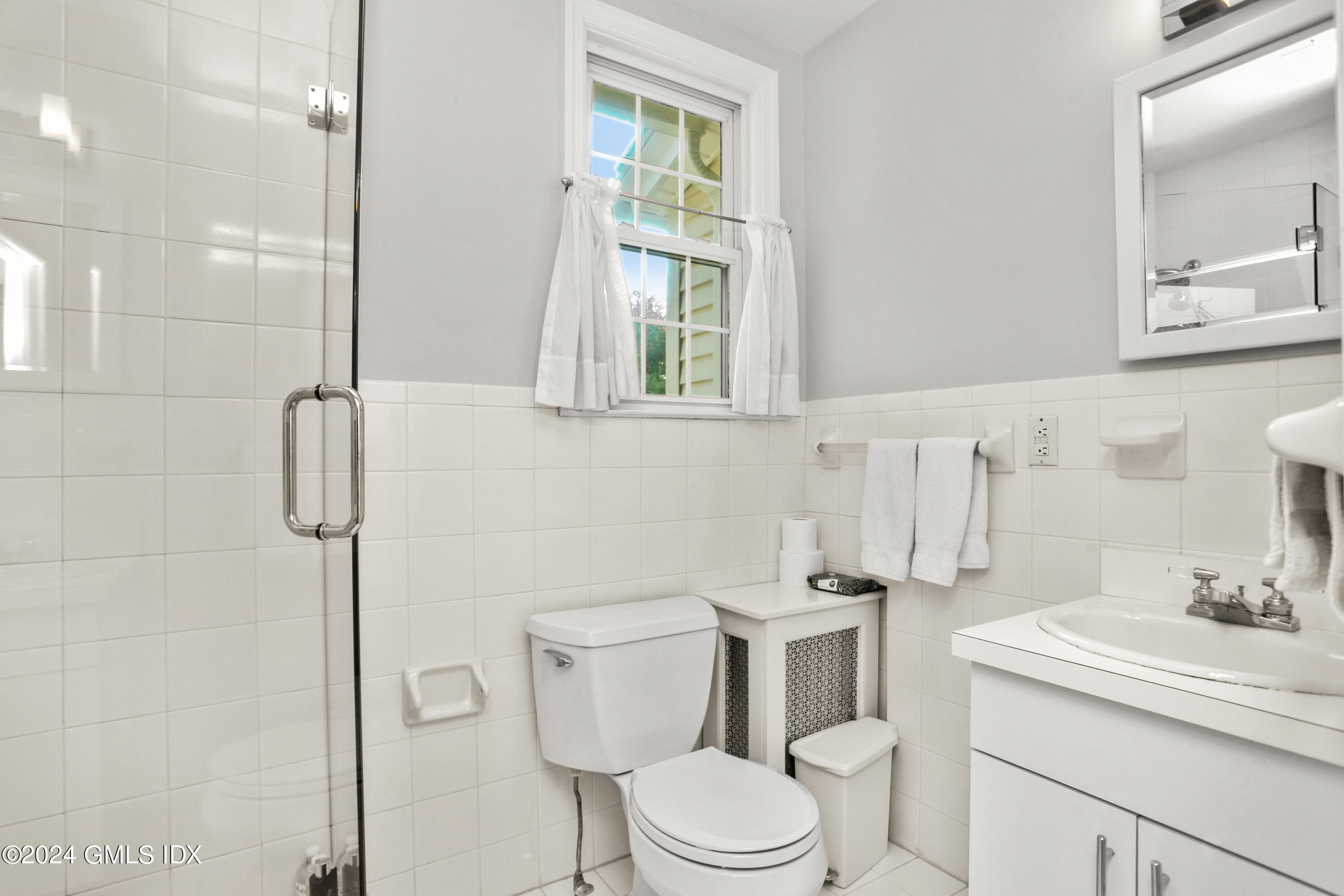 18 Shore Road Old Greenwich, CT 06870 - Photo 21 of 51 a bathroom with a toilet sink vanity and mirror