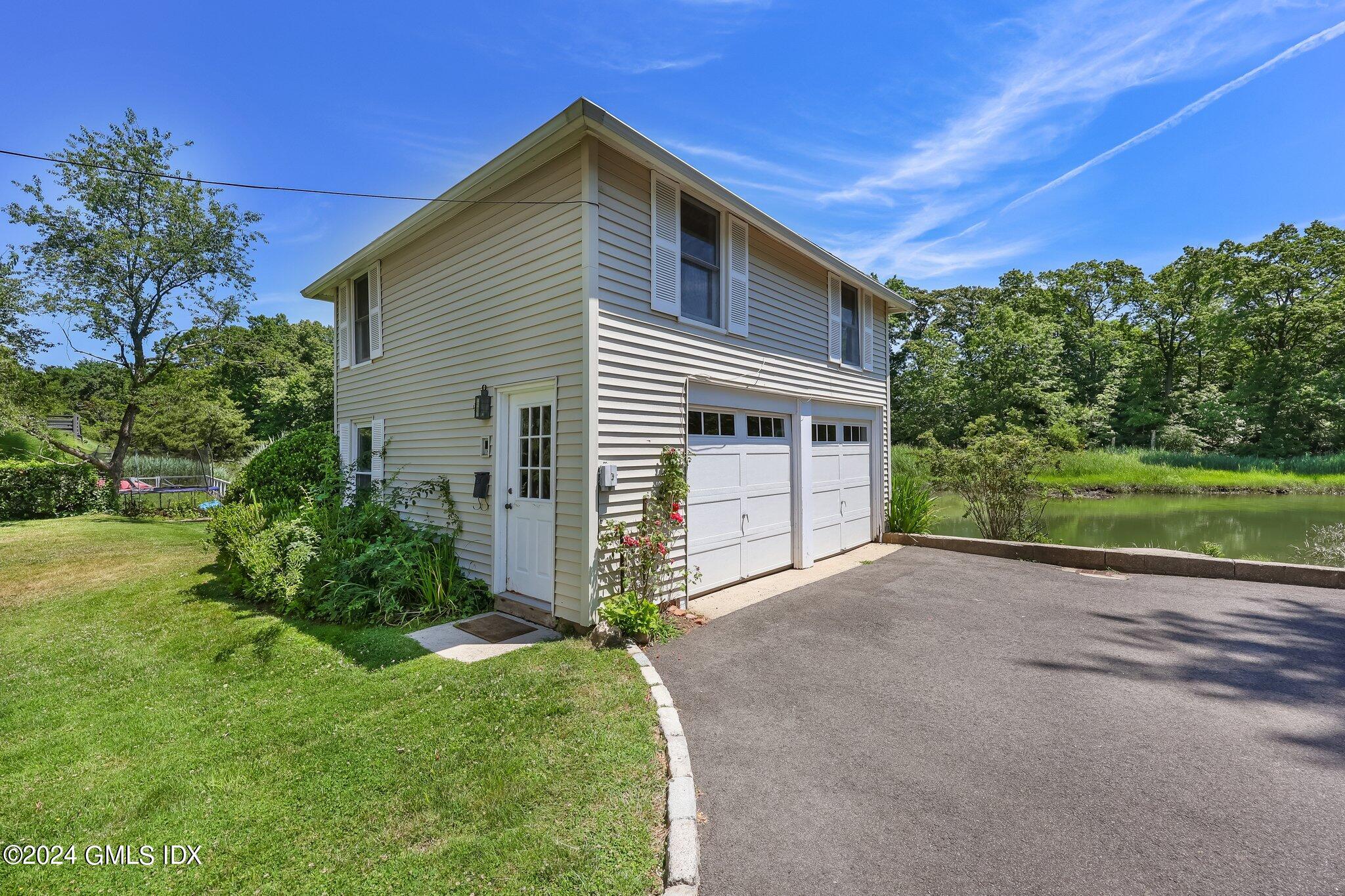 18 Shore Road Old Greenwich, CT 06870 - Photo 34 of 51 a front view of a house with a yard and garage