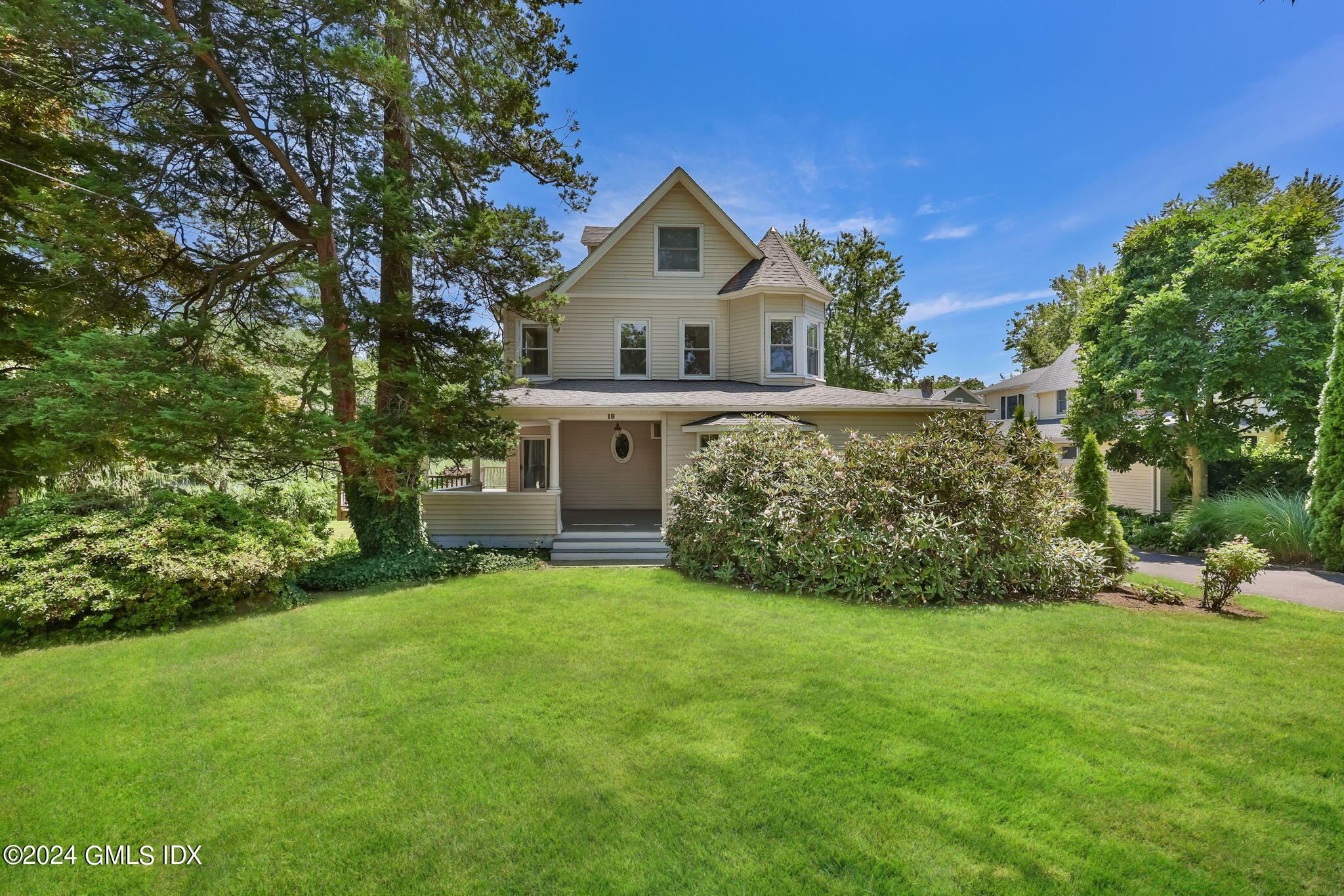 18 Shore Road Old Greenwich, CT 06870 - Photo 45 of 51 a front view of a house with a garden and yard