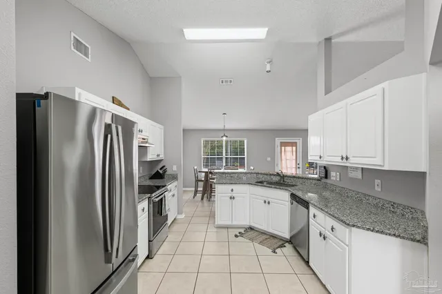 a kitchen with granite countertop sink stove and cabinets