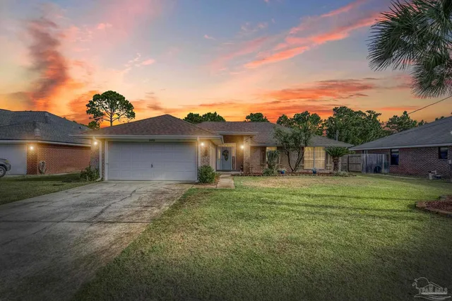 a view of a house with a yard and a garage