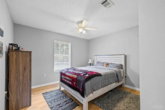 a bathroom with a granite countertop sink a toilet a mirror and shower curtain