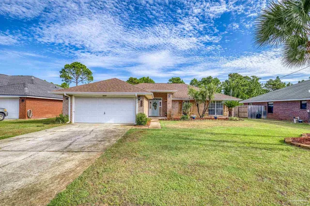 a front view of a house with a garden and yard