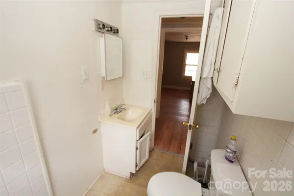 a walk in closet with wooden floor and a window