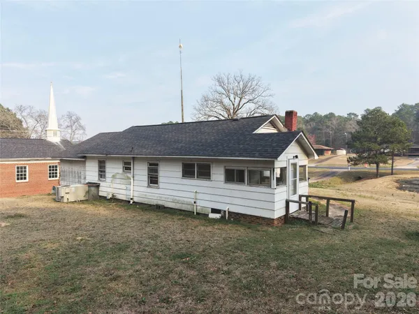 a view of a house with a yard and sitting area