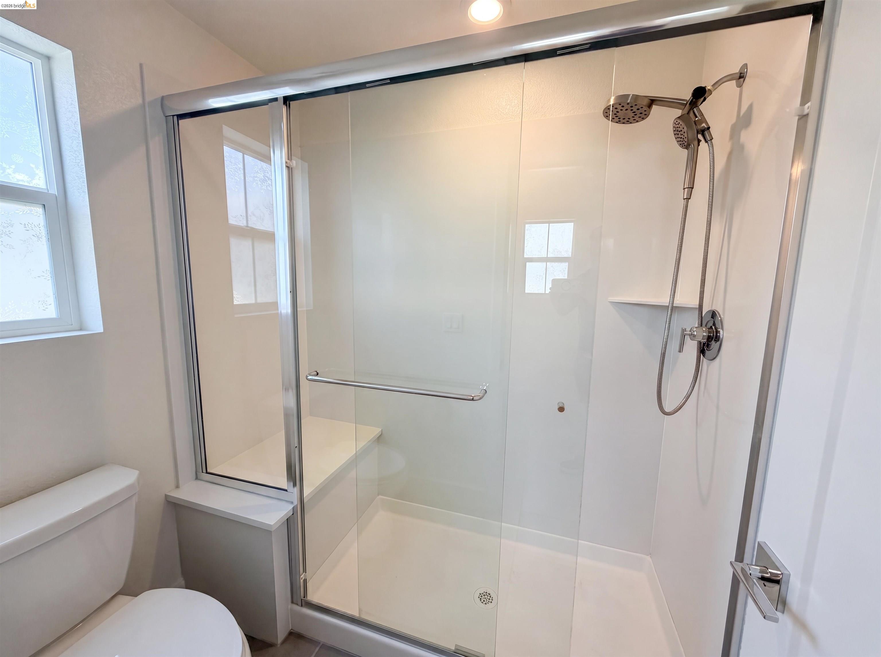 9034 Rudder Way Newark, CA 94560 - Photo 19 of 38 Walk-in shower featuring a sliding glass door, integrated bench, and dual showerheads