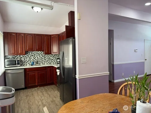 a kitchen with stainless steel appliances granite countertop a refrigerator and a stove top oven