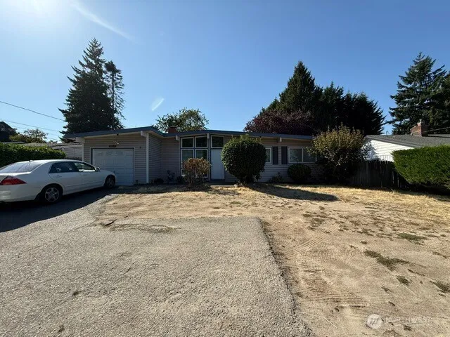 a view of parking area covered with snow in front of house