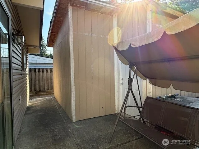 a view of a house with a small yard and wooden fence
