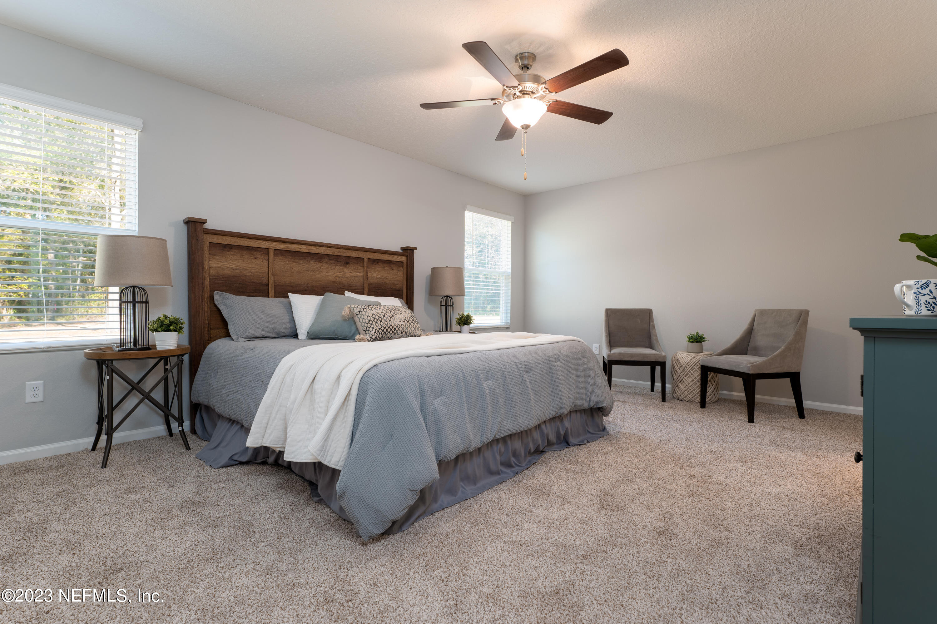 12701 Dunn Creek Road Jacksonville, FL 32226 - Photo 24 of 51 a bedroom with a bed a chair and a large window