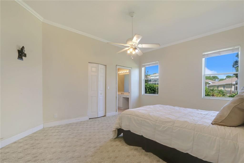 2539 Southeast Springtree Place Stuart, FL 34997 - Photo 7 of 20 a bedroom with a bed and a chandelier