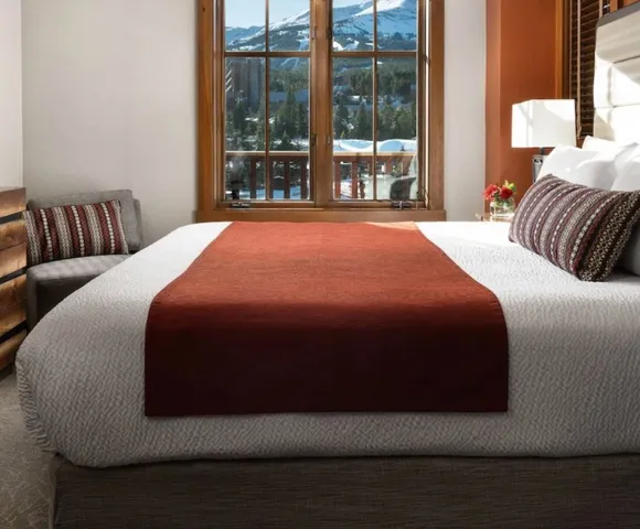 a large bed sitting in a bedroom next to a large window