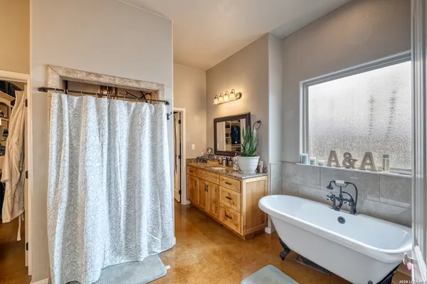a bathroom with a granite countertop sink a mirror a vanity and a shower