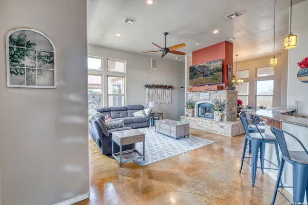 a living room with furniture a fireplace and a chandelier