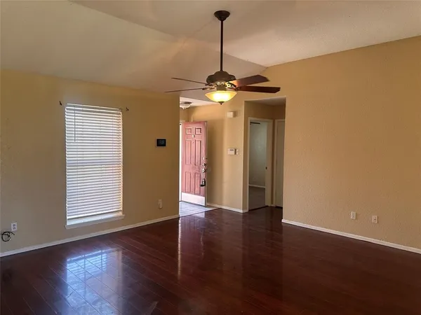a view of a room with wooden floor chandelier and windows