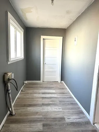 a view of a room with a dresser wooden floor and a window