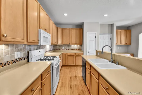 a kitchen with a sink a counter top space cabinets and stainless steel appliances