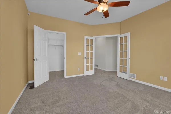 a view of an empty room with a chandelier fan