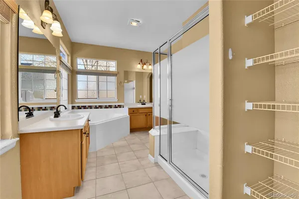 a large bathroom with a tub a sink a mirror and a shower