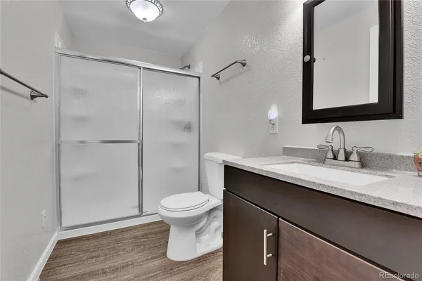 a bathroom with a granite countertop sink toilet and shower
