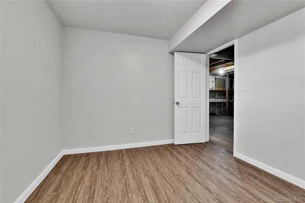 a view of empty room with wooden floor and space